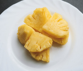 Pineapple slices in white plate.
