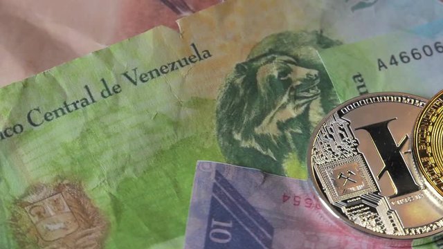 Physical metal Bitcoin currency over bolivar bills. Virtual internet money with Venezuelan banknotes. Digital coin cyberspace, cryptocurrency. BTC golden coin as symbol of electronic virtual money. 4K