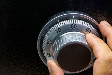 Close-up of hand searching security code of safe.