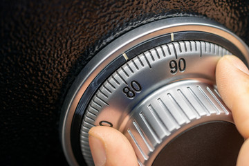 Close-up of hand searching security code of safe.
