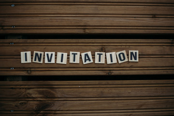 Invitation. Text on a wooden background