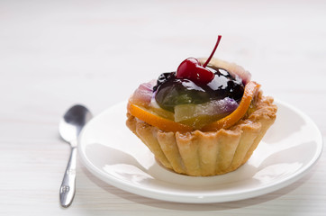 basket cake decorated with different fruit on white table