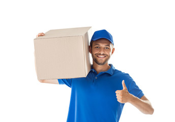 Smiling young delivery man with parcel box showing thumbs up