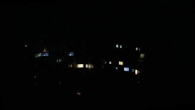 Facade with many windows, exterior of a modern apartment block at night, close up, shallow depth of the field, 59,94 fps