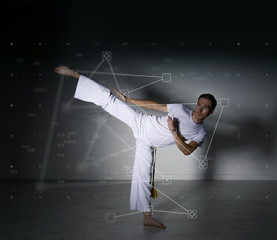Man in white sportswear performing a kick. Sport science, biomechanics, information technology concept.