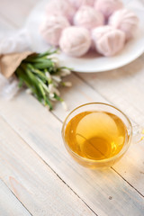 Tasty pink zephyr with honey and flowers on a wooden table. It can be used as a background