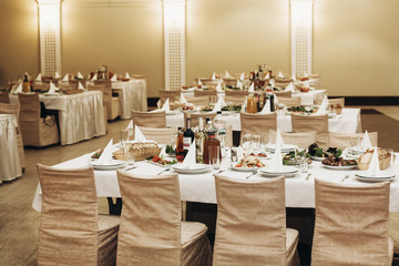 Luxury business dinner reception at expensive restaurant with beige decorations, table set...