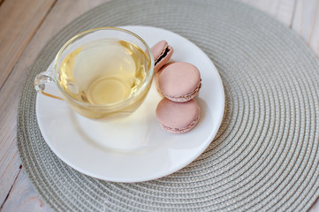 Tasty pink macaroons on a wooden table. It can be used as a background