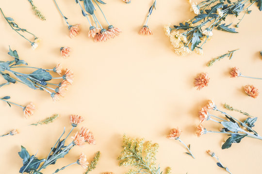 Fototapeta Autumn floral composition. Frame made of fresh flowers on pastel yellow background. Autumn, fall concept. Flat lay, top view, copy space