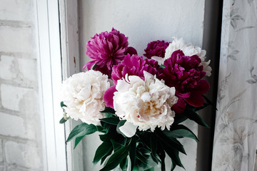 beautiful bunch of peonies in vase on wooden white window sill background, rustic wallpaper concept, space for text