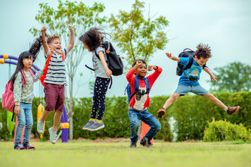 kids preschool kindergarten enjoy and happy jumping on the field of playground after school class...