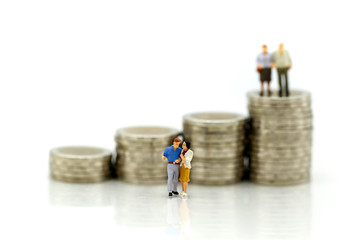 MIniature people : Couple in love standing on stack of coin. Money, Love and Valentine's day concepts.