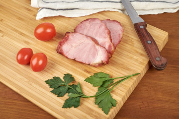 Cooked sliced pork barbecue steak on wooden cutting board.