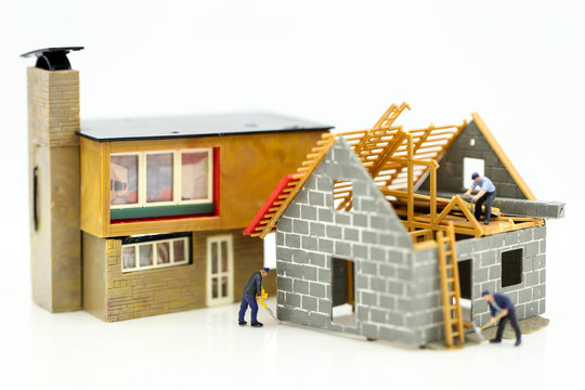 Miniature people : worker team for building home ,Image use for construction, business concept,house repair or home renovating