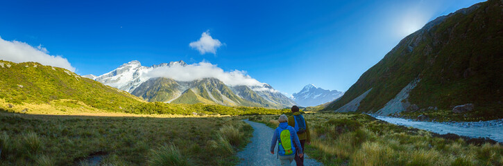 Panorama of Couple hiking on Hooker Valley Track in South island New Zealand, Mount cook national park, summertime