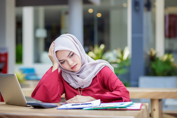 Feeling tired. Young asian muslim woman feeling stress from work.
