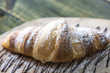Slate plate with tasty croissants on table