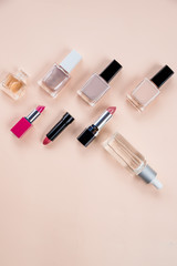 Obraz premium Colorful frame with various makeup products on pastel background. cosmetics, skin care, perfume, nail Polish, lipstick flat lay and skin oil bottle over a beige background.Beauty products concept.Copy