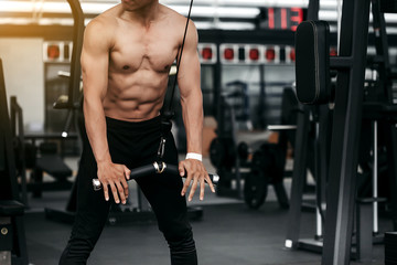 Fototapeta na wymiar Man training on exercise machine in gym