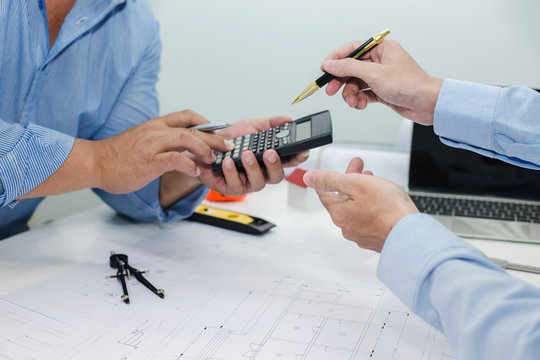 Businessman and engineer discuss at meeting about housing project.