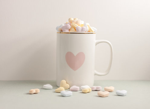 one white cup full of candy hearts