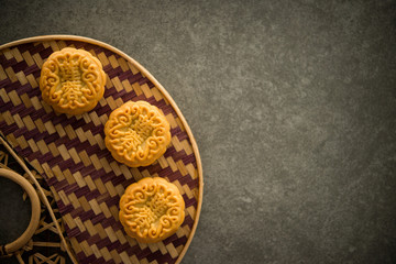 Moon cakes on bamboo background low light with copyspace