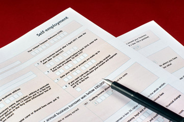Naklejka na ściany i meble pen and self employment tax form on red velvet background