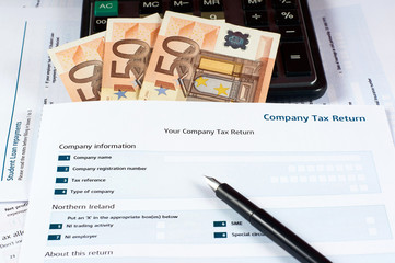 Fototapeta na wymiar pen, money, calculator and company tax return form