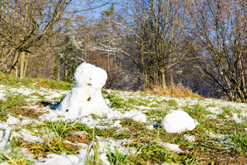 schmelzender Schneemann in der grünen Wiese