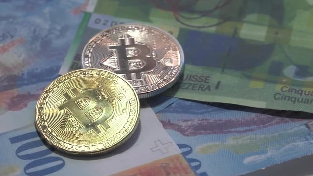 Physical metal Bitcoin currency over bolivar bills. Virtual internet money with Venezuelan banknotes. Digital coin cyberspace, cryptocurrency. BTC golden coin as symbol of electronic virtual money. 4K