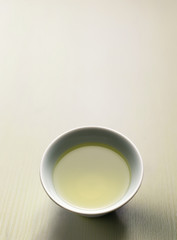 A cup of hot green tea on the table.