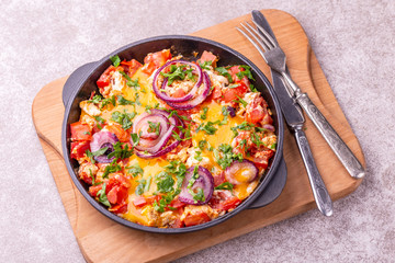 Shakshuka with toasts. Fried eggs with tomatoes, vegetables and herbs