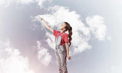 Concept of careless happy childhood with girl dreaming to become