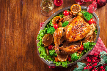 Baked or roasted whole chicken on Christmas table