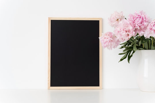 White portrait frame mock up with a pink peonies beside the frame, overlay your quote, promotion, headline, or design, great for small businesses, lifestyle bloggers and social media