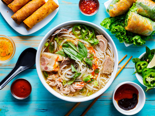 colorful vietnamese pho bo with beef and spring rolls - obrazy, fototapety, plakaty