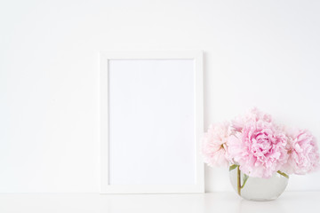 Minimal feminine white blank a4 frame mockup. Floral bouquet of pink peonies in transparent vase. Background, mock up for quote, promotion, headline, design, lifestyle bloggers and social media