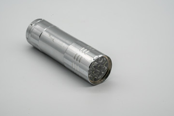 Silver metal damaged flashlight isolated on white