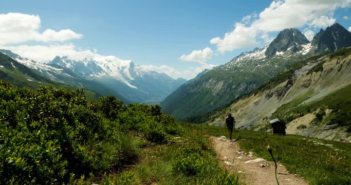 footage of the mont blanc massif near chamonix in the french alps showing clouds moving against blue summer sky and green alpine meadows