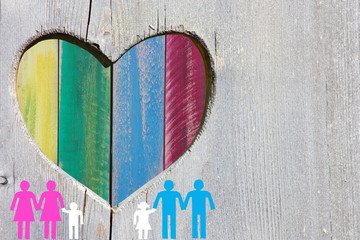 Gay and lesbian families on wooden background with multicolor rainbow heart