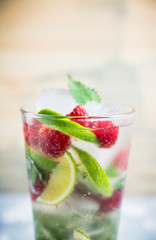Raspberry mojito cocktail on the wooden background. Selective focus. Shallow depth of field.