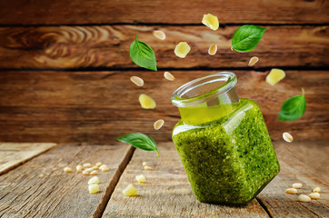 Pesto sauce with flying ingredients to prepare it