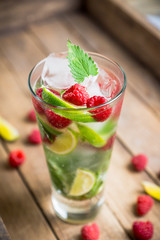 Raspberry mojito cocktail on the wooden background. Selective focus. Shallow depth of field.