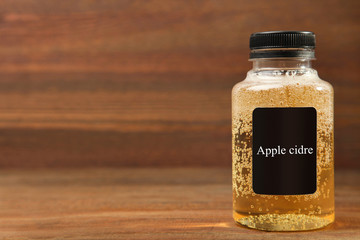 Apple cider in a jar on a brown wooden background.