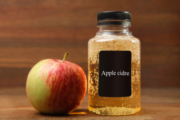 Apple cider in a jar on a brown wooden background.