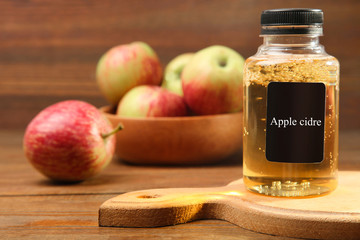 Apple cider in a jar on a brown wooden background.