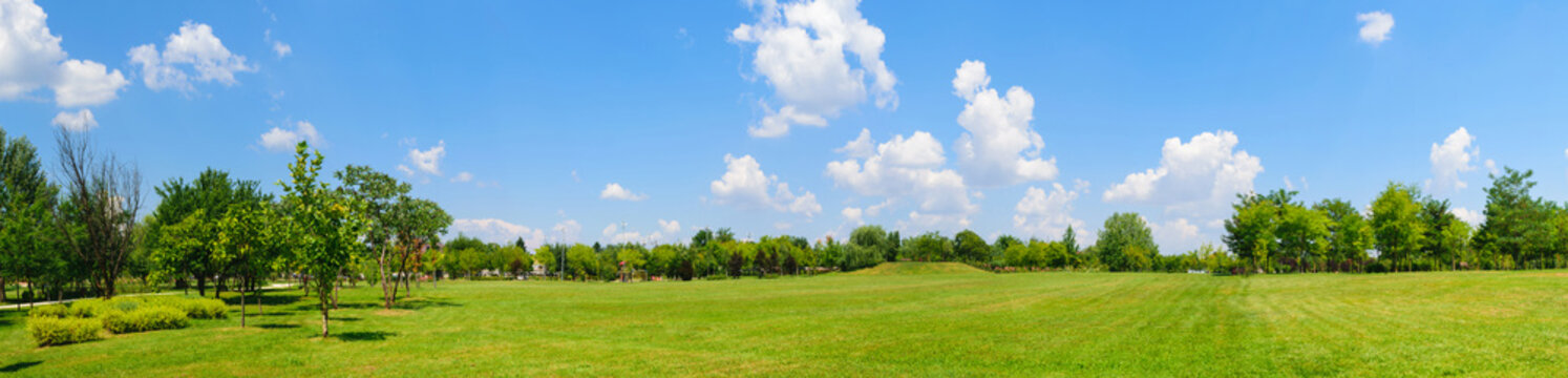panorama of green lawn field with trees in the background. Park at Mogosoaia Palace near Bucharest, Romania.