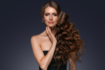 Naklejka premium Beautiful hair long curly hairstyle woman with beauty makeup female model portrait