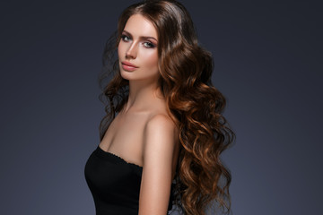 Naklejka premium Beautiful hair long curly hairstyle woman with beauty makeup female model portrait