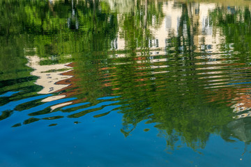 Fototapeta na wymiar Häuser spiegeln sich im klaren Wasser eines Flusses